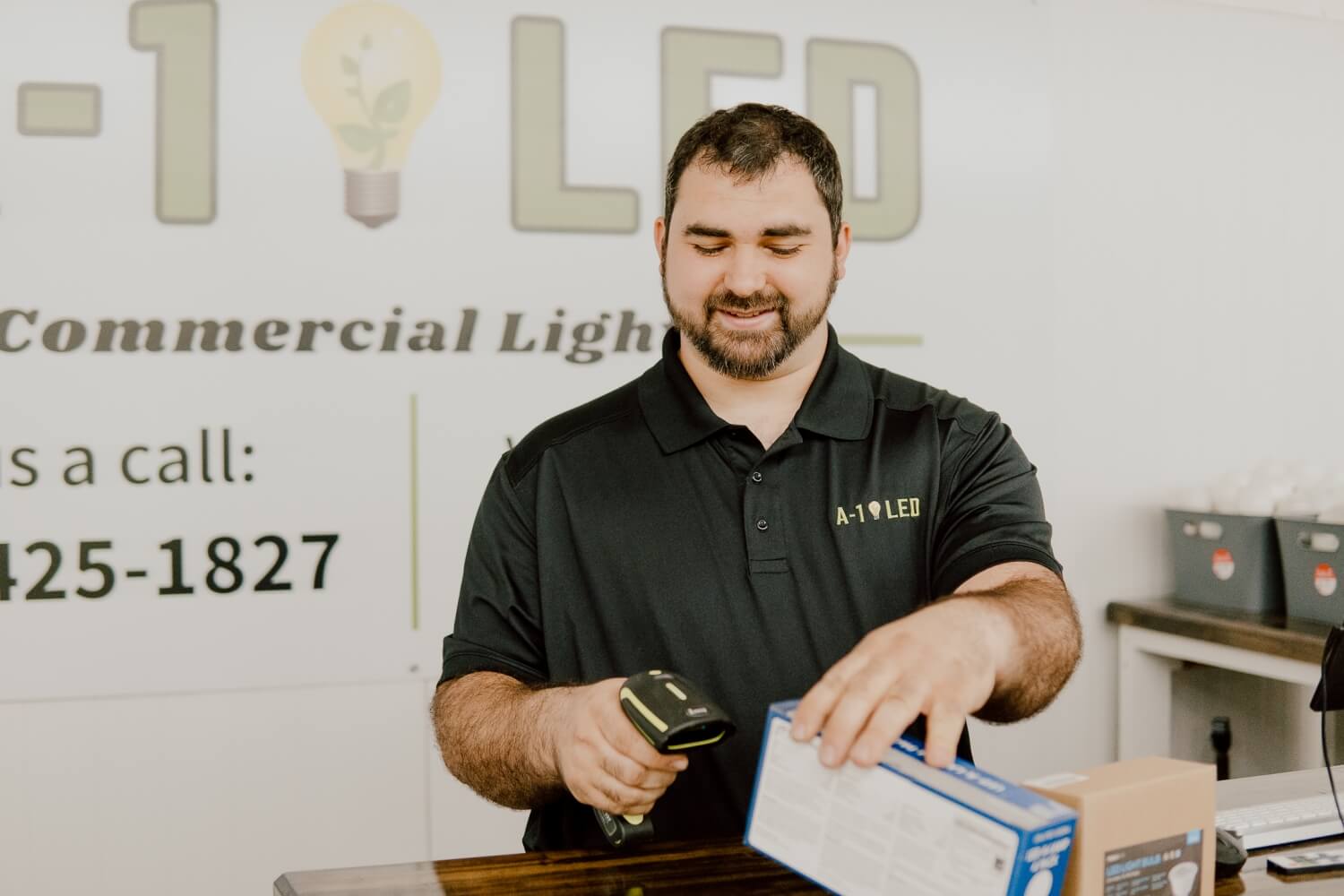 An A-1 LED Direct employee scans a product box, showcasing the hands-on approach to customer service in their nationwide LED sales operations.