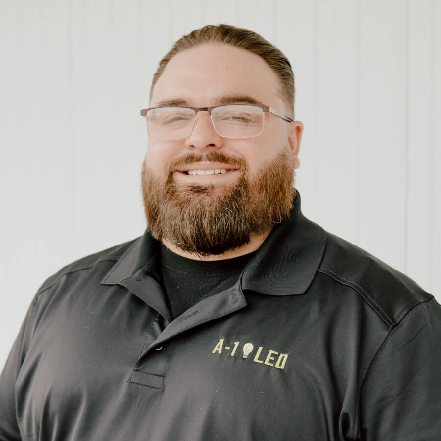 Wesley Davis, the Chief Operating Officer of A-1 LED, pictured in a professional headshot wearing a black A-1 LED uniform, conveys a friendly and confident presence essential for operational leadership.